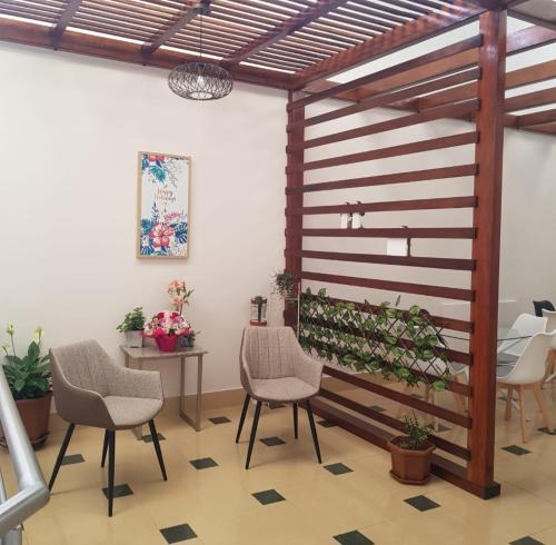 Habitación con sillas, mesa y pared con plantas. en HOTEL SHANGHAI CITY, en Ibarra