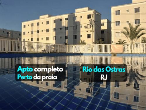 a picture of a swimming pool in front of two buildings at Lindo Apartamento perto da praia in Rio das Ostras