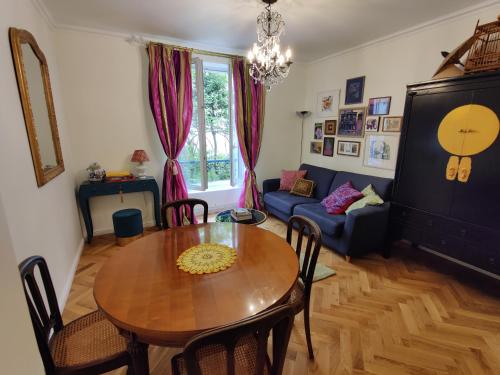 uma sala de estar com uma mesa e um sofá em Cozy apartment with a garden view in the 17th quartier em Paris