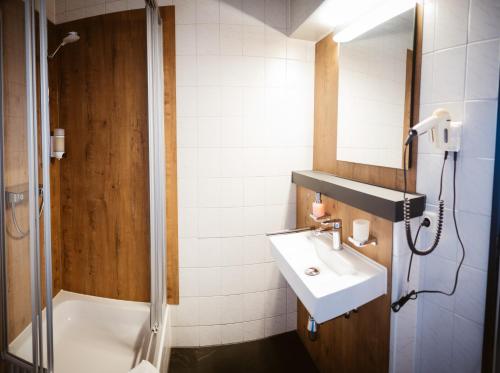 a bathroom with a sink and a shower at Hotel Rheinpromenade8 in Emmerich