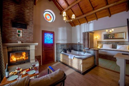 アグヴァにあるWineport Lodge Agvaのバスルーム(バスタブ付)、ベッド1台、暖炉が備わります。