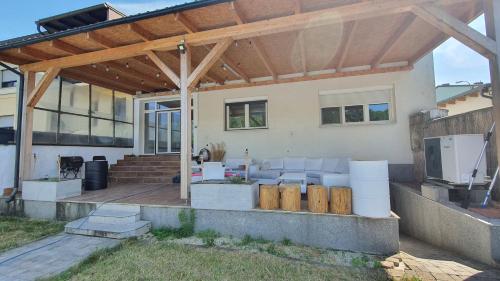 une pergola en bois sur une terrasse d'une maison dans l'établissement 4 room flat with garden and pool, à Kittsee