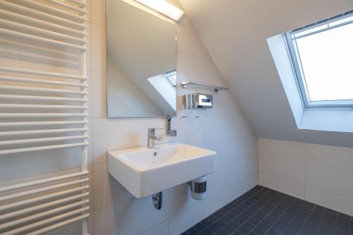 baño con lavabo y ventana en Das Loft Apartments, en Aachen
