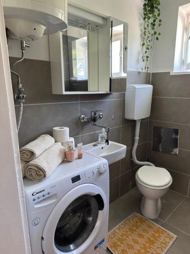 a bathroom with a washing machine and a toilet at Cosy Family Apartment Marina Kastela near Airport in Kaštela