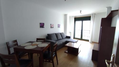 - un salon avec un canapé et une table dans l'établissement Apartamento terra1, à Caldas de Reis