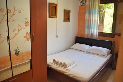 Un pequeño dormitorio con una cama con toallas. en Port House en Zagora