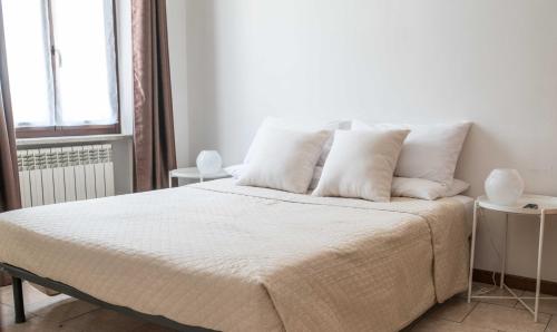 a bedroom with a bed with white sheets and pillows at "Le Charmant" - CIR VDA-SAINT-VINCENT-n 0004 in Saint Vincent