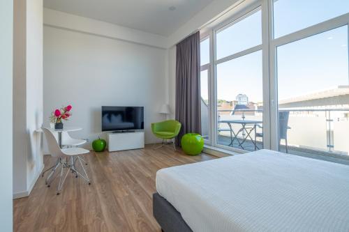 una camera d'albergo con un letto e una grande finestra di Das Loft Apartments ad Aquisgrana