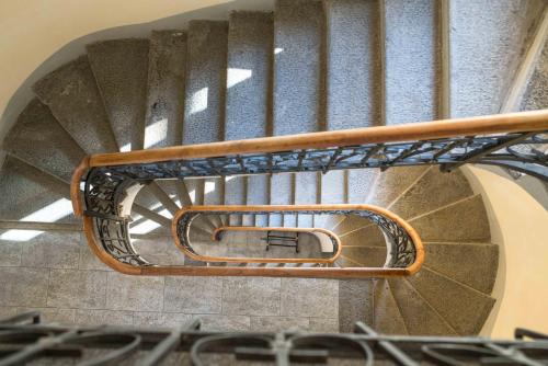 a spiral staircase in a building with a metal railing at "Le Charmant" - CIR VDA-SAINT-VINCENT-n 0004 in Saint Vincent