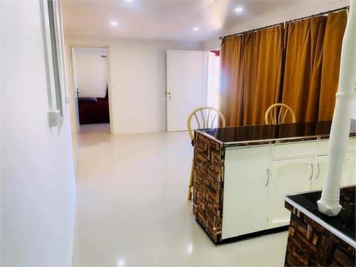 a kitchen with a counter and a room with a curtain at Town Centre Stays in Nadi