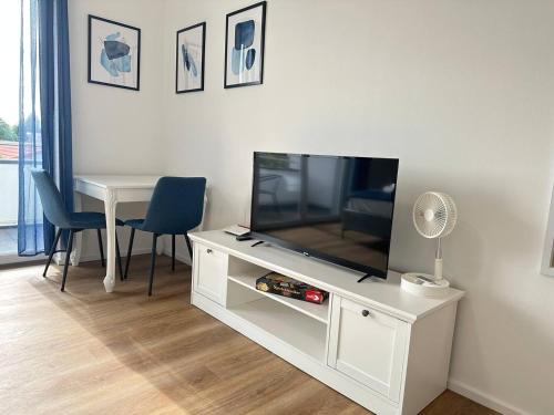 a living room with a television on a white entertainment center at SUITE4ME - Balkon I Küche I Waschmaschine I Mainz-Kostheim in Wiesbaden