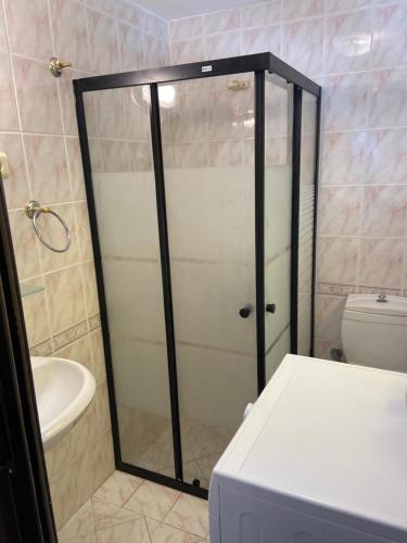a shower with a glass door in a bathroom at Artur holiday city - double room in Gomec