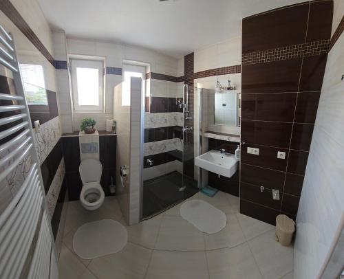 een badkamer met een douche, een toilet en een wastafel bij Privat Agnesa in Zuberec