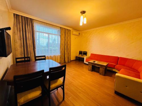 a living room with a red couch and a table at Apartments NITA in Batumi
