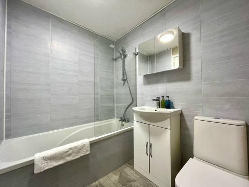 a bathroom with a toilet and a tub and a sink at Fab Oxford City Centre Apartment sleeps 6 with in Oxford
