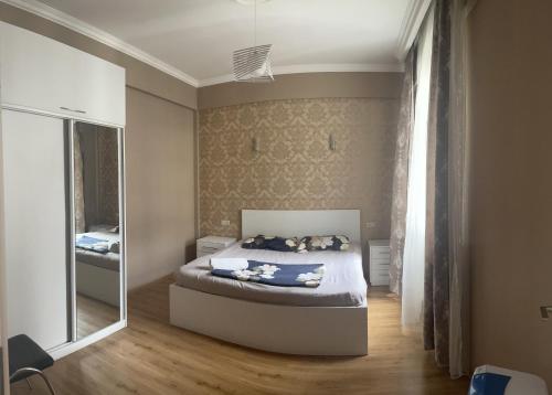 - une petite chambre avec un lit et un miroir dans l'établissement Holiday apartment, à Tbilissi