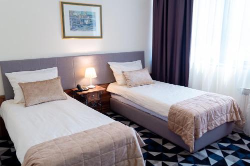 a hotel room with two beds and a window at Hotel Art in Sarajevo