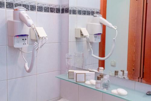 a bathroom with two hair dryers and a mirror at Hotel Art in Sarajevo