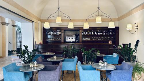 a restaurant with round tables and blue chairs at Hotel Palazzo Piccolomini in Orvieto