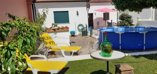 a patio with a table with a bottle and a pool at Cantinho dos moinhos in Figueira da Foz