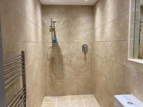 a bathroom with a shower with a shower head at Four Candles Retreat - Stunning 2 Bd No Guest Fees in Kent