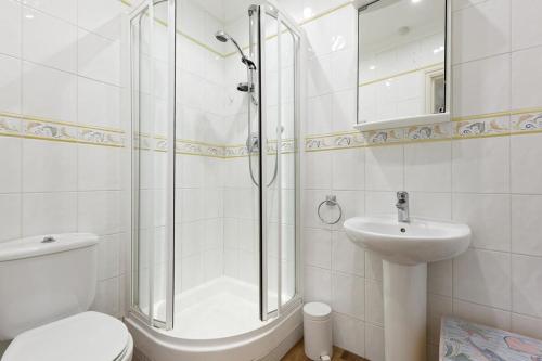uma casa de banho com um chuveiro, um WC e um lavatório. em Luna's Seaview Apartment Sleeps 4 Parking Beach em Kent