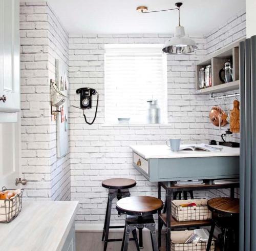a kitchen with white brick walls and stools at Old Town Retreat, Grade Ii Listed, Margate Kent in Kent