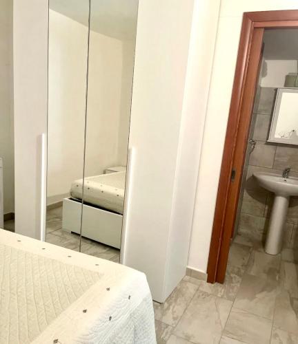 a bedroom with a mirror and a bed and a sink at Casa Funtana e Susu in Jerzu