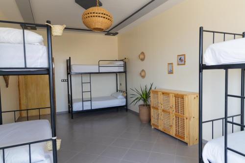 a room with four bunk beds in it at Wavy Days in Tamraght Ouzdar