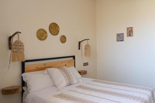 a bedroom with a bed and some plates on the wall at Wavy Days in Tamraght Ouzdar