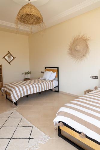 two beds sitting in a room with at Wavy Days in Tamraght Ouzdar