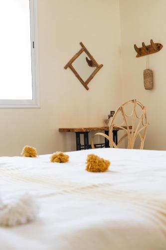 a white bed with teddy bears on top of it at Wavy Days in Tamraght Ouzdar