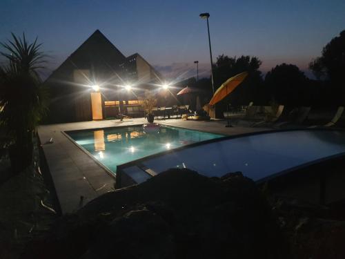 uma piscina à noite com um edifício ao fundo em Grand gîte Touraine 300m2 em La Membrolle-sur-Choisille