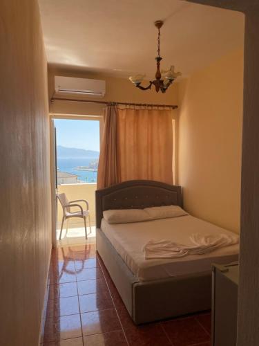 a bedroom with a bed and a window with a view at Hotel Gjika in Sarandë