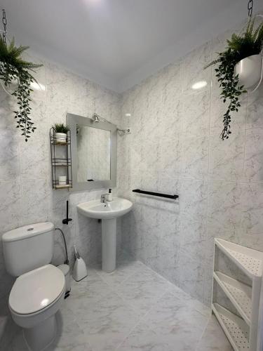 a white bathroom with a toilet and a sink at casa EDEN in Torre del Mar