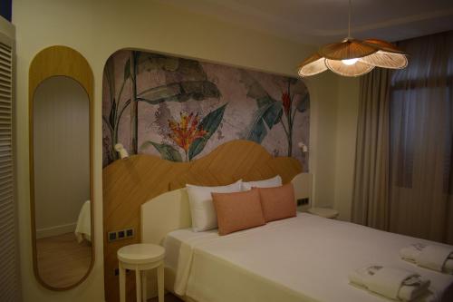 a bedroom with a bed with a painting on the wall at IMMYS in Seferihisar
