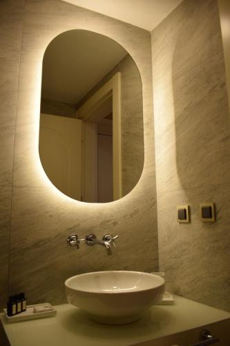 uma casa de banho com um lavatório e um espelho em IMMYS em Seferihisar