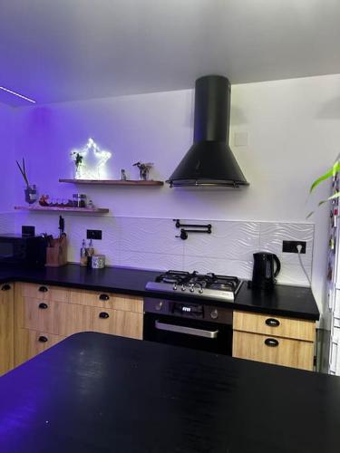 - une cuisine avec une cuisinière et un mur pourpre dans l'établissement Appartement Familiale et équipée - Vue mer, à Port-de-Bouc