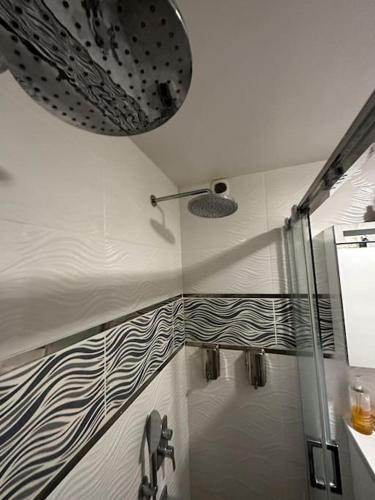 une salle de bain avec une douche avec une porte vitrée dans l'établissement Appartement Familiale et équipée - Vue mer, à Port-de-Bouc