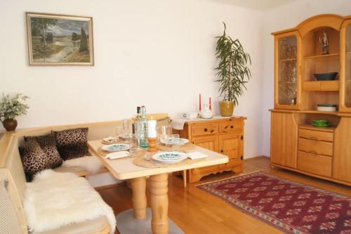 a dining room with a table and a couch at Alpen Apartments Salzburg in Lessach
