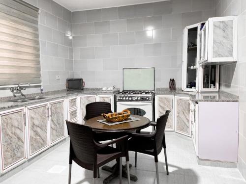 La cuisine est équipée d'une table, de chaises et d'un réfrigérateur. dans l'établissement west view hostel, à ‘Ayn Amūn