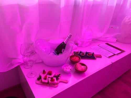 een roze bureau met een fles wijn en glazen bij Sergio’s home in Vittoria