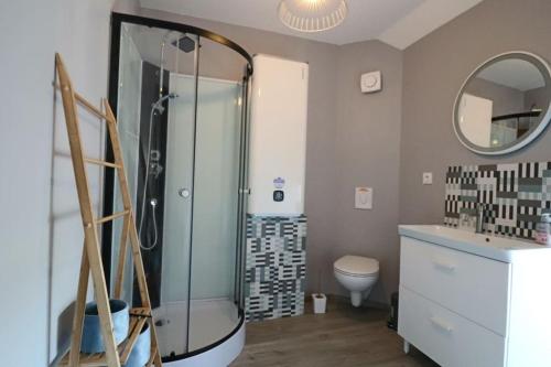 La salle de bains est pourvue d'une douche en verre et de toilettes. dans l'établissement Gîte Cottage, cosy entre terre et mer, à Vesly