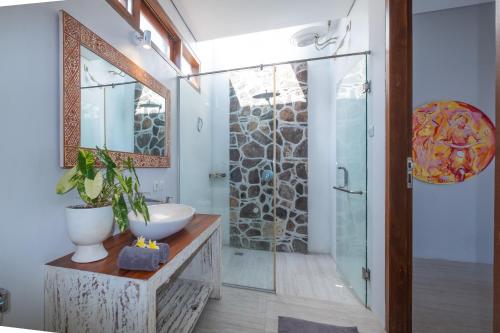 a bathroom with a sink and a glass shower at Kamana Beach House in Mangsit