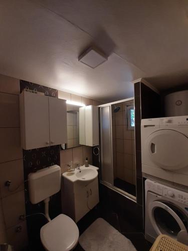 a small bathroom with a sink and a washing machine at View in Sarajevo
