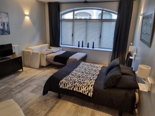 a hotel room with two beds and a window at Grand appartement près de la Cathédrale de Quimper in Quimper