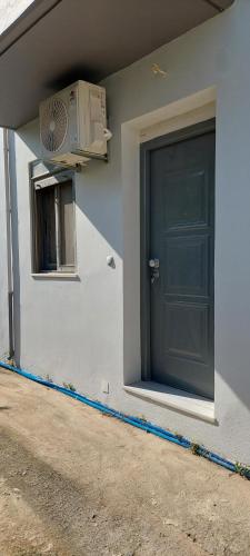 ein Gebäude mit einer Tür und einer Klimaanlage in der Unterkunft Όμορφο στούντιο στη Χίο! Α2 in Chios