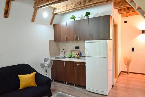 a kitchen with a white refrigerator and wooden cabinets at Freedom in Forest in Jajce