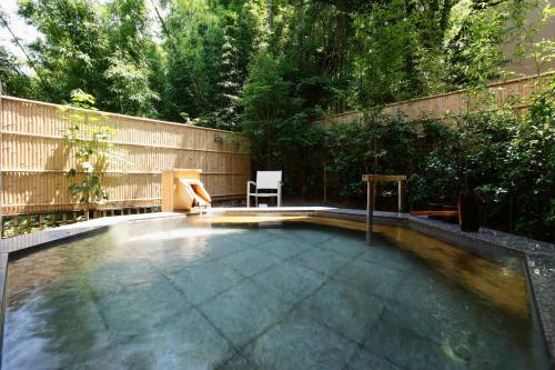 a swimming pool in a backyard with a wooden fence at Fufu Atami in Atami