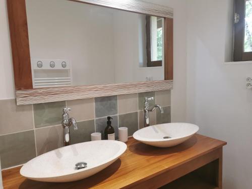 deux lavabos sur un comptoir en bois dans une salle de bain dans l'établissement Gîte la Borie du bois Sarlat, à Saint-André-dʼAllas